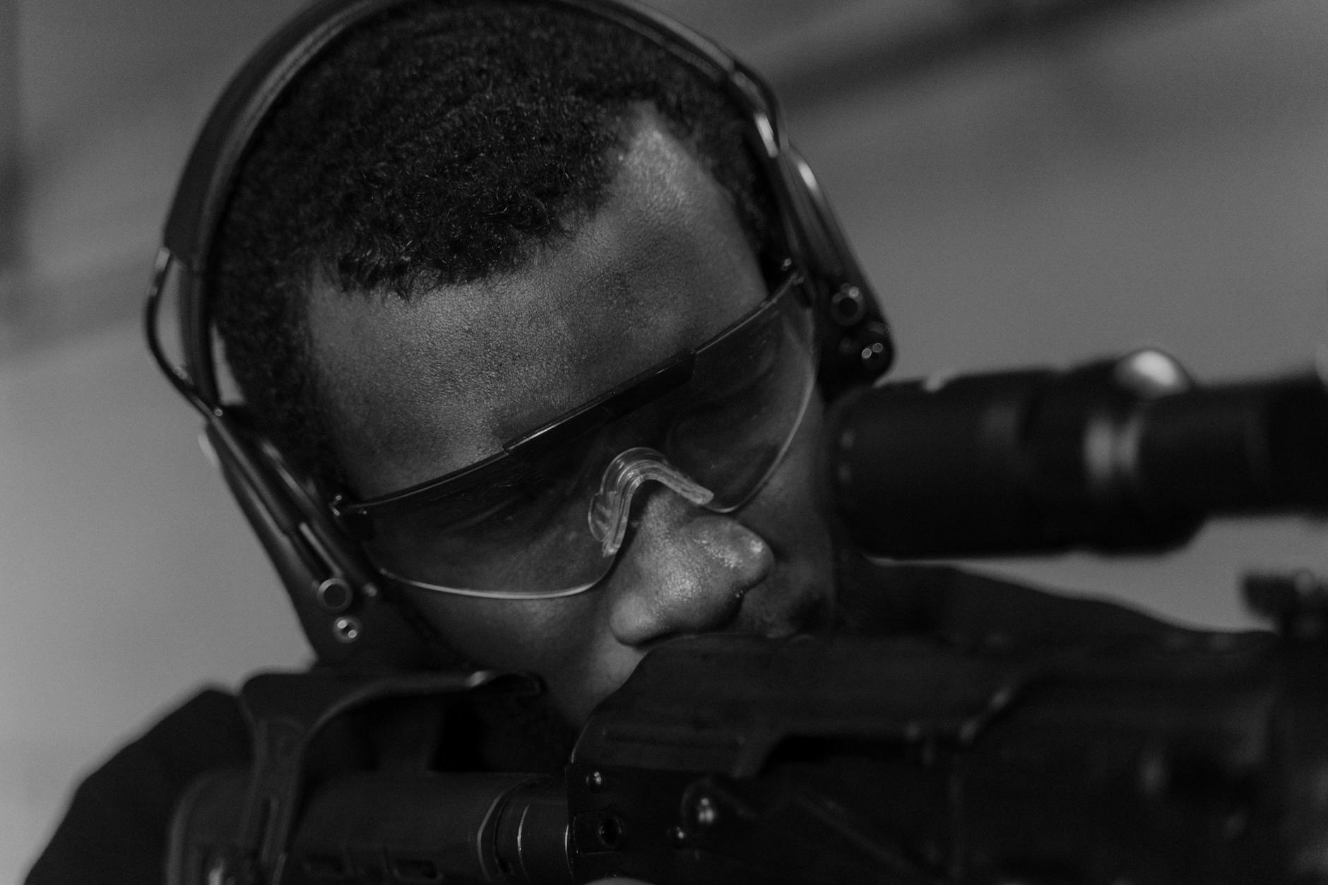 man wearing black sunglasses holding black rifle